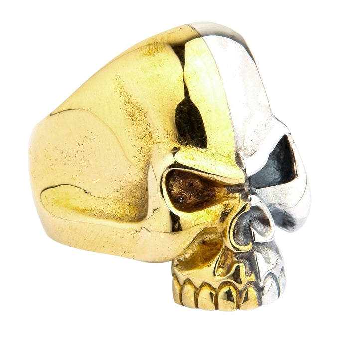 Side profile of the split-face skull ring highlighting the contrast between the warm brass and cool sterling silver halves.