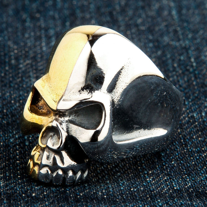Close-up resting on dark denim, showcasing the reflective sterling silver jaw and contrasting warm brass brow ridge.