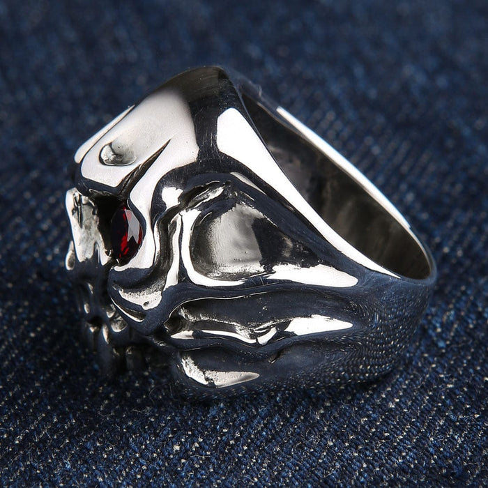 A detailed close-up of the gothic skull ring, focusing on the brilliant red stone and polished fangs.