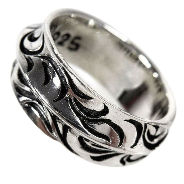 Angled view of a 10mm sterling silver band featuring a deeply carved, continuous wave pattern with shadowed troughs.