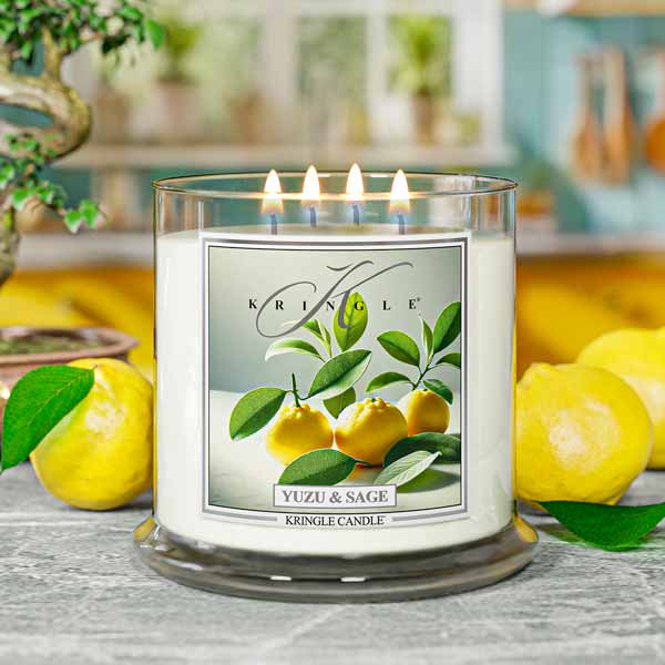 Kringle Candle with yuzu and sage design on a table with lemons